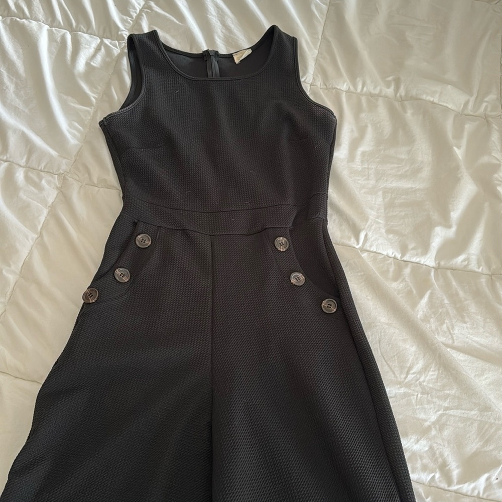 Black sleeveless jumpsuit with pockets and brown buttons